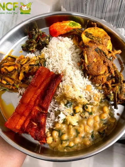 A hearty non-veg thali featuring fried pork ribs, fish curry (nga thongba), crispy fritters (bora), a spicy mash (ametpa), and a lentil dish (ooti).