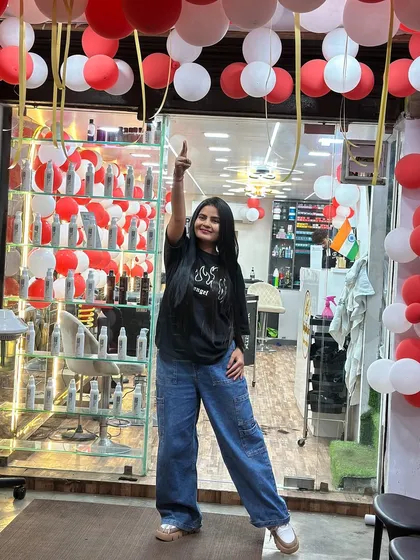 A happy client showing off her new look after a Botox hair treatment. The salon is decorated, but the hair is the real star.