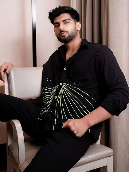 This indoor shot was created for a clothing brand's catalogue. The clean, modern chair and simple background ensure the focus is on the unique design of the shirt, highlighting the graphic print and details.