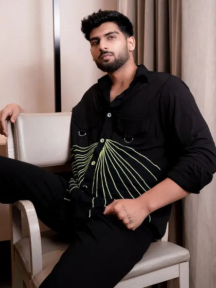 A model seated in a modern chair, wearing a shirt with a unique graphic design. This shot is great for e-commerce listings or a brand's social media.