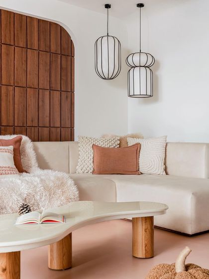 A detail of the family lounge, showing the custom-designed coffee table and sofa against a backdrop of warm wood paneling.