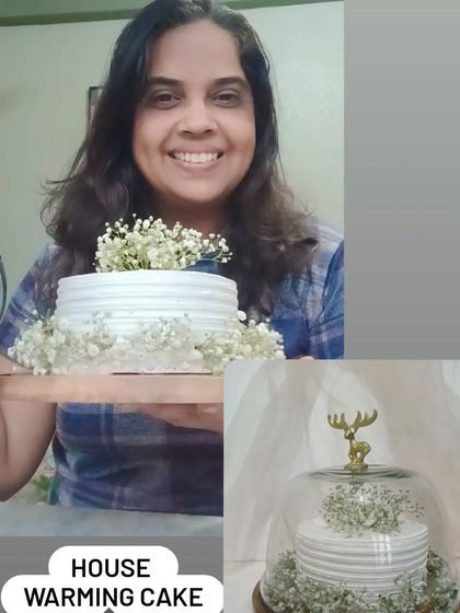Me holding a simple and elegant housewarming cake decorated with baby's breath flowers.