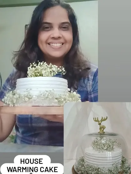 Me holding a simple and elegant housewarming cake decorated with baby's breath flowers.