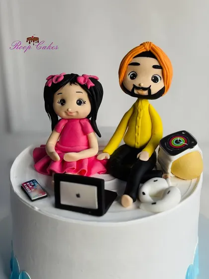 A closer look at the detailed, handcrafted fondant figurines of the father and daughter, capturing a sweet moment for a birthday celebration.