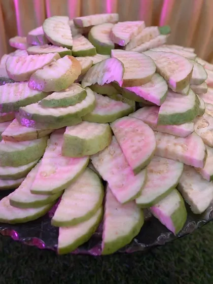 A platter of freshly sliced pink guava, a simple yet refreshing option for guests.
