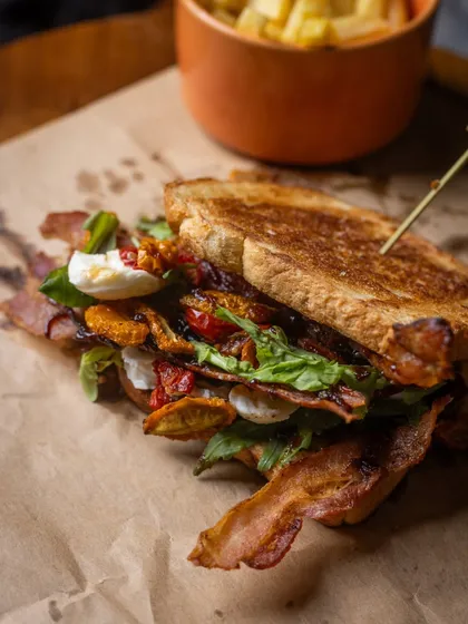 This isn't your everyday BLT. I've layered crispy bacon, fresh arugula, and sweet onion jam with a creamy aioli, all tucked inside soft milk bread. It’s a sandwich that’s both comforting and a little adventurous.