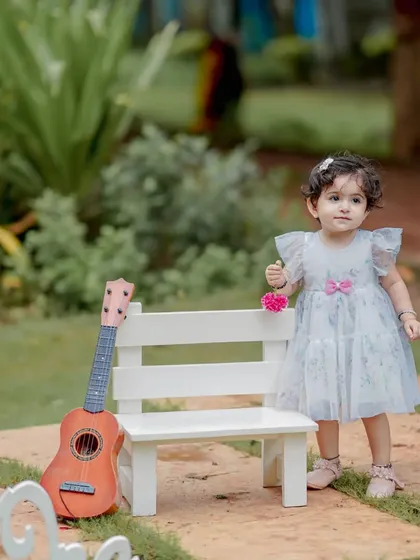 A tiny musician and her guitar. This setup with a miniature bench and instrument is perfect for a whimsical and sweet portrait of a baby girl. The natural garden setting adds to the soft, dreamy feel.
