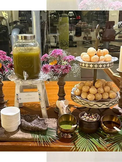 A beautifully styled Golgappe station, complete with a dispenser for the spicy water and bowls of delicious fillings. The setup is decorated with fresh flowers for an elegant touch.