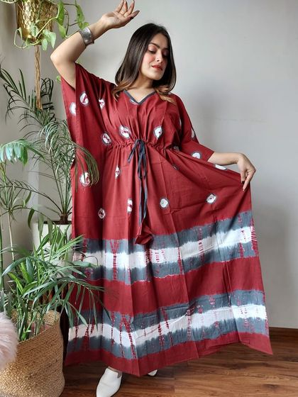 A maroon and white tie-dye kaftan with a mix of patterns. The adjustable waist ensures a perfect fit for everyone.