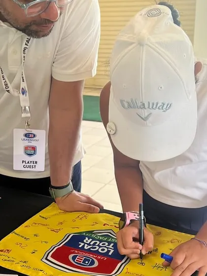 Jenaya Bamnyal signs an autograph board, a moment from the US Kids Golf Championship where she showcased great consistency.