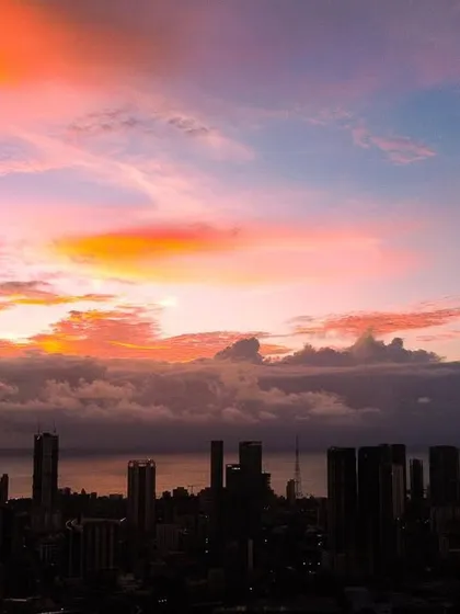 A stunning shot where the sky above Mumbai looks like a painting, with fiery orange clouds against a blue and pink canvas.