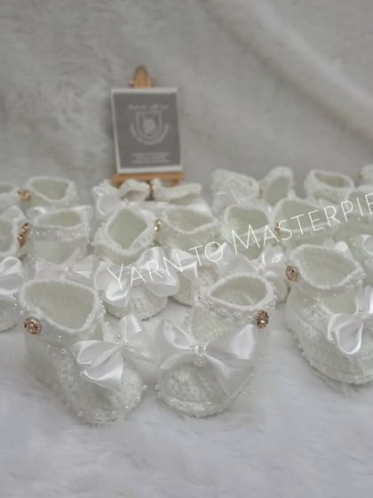Another view of a bulk order of my white baptism booties, showing the consistent quality and care I put into every single pair I make.