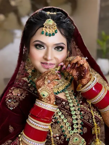 Our beautiful bride, ready for her wedding ceremony. The makeup features dramatic winged eyeliner and a perfectly blended base, paired with heavy kundan jewelry for a complete and stunning bridal transformation.