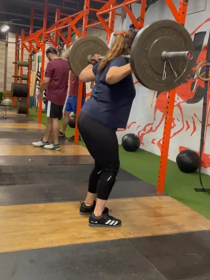This client is in the receiving position of a drop snatch, showing the depth and stability required for heavy lifts.