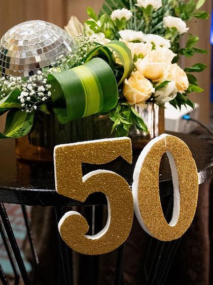 A close-up of a centerpiece from the 50th birthday party. The mini disco ball and glittery "50" sign were fun, festive details that added to the celebratory mood.