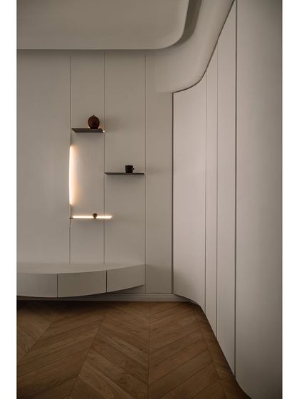 A different perspective of the master bedroom's curved vanity and wardrobe, showcasing the seamless and sculptural quality of the design.