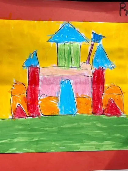 The finished castle drawing, colored in with bright, imaginative hues. The student has successfully built upon the initial sketch to create a complete scene.