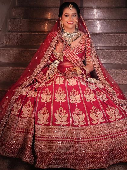 A full-length view of a stunning bride in her traditional red wedding lehenga. My goal is to create a cohesive look where the makeup, hair, and outfit all come together in perfect harmony.