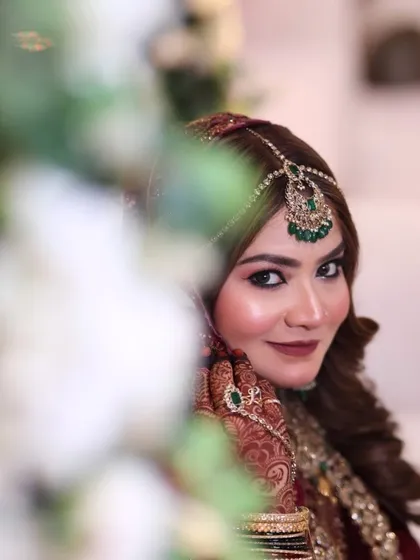 A direct, smiling portrait that shows her confidence. The makeup is designed to look perfect both in person and in photographs.
