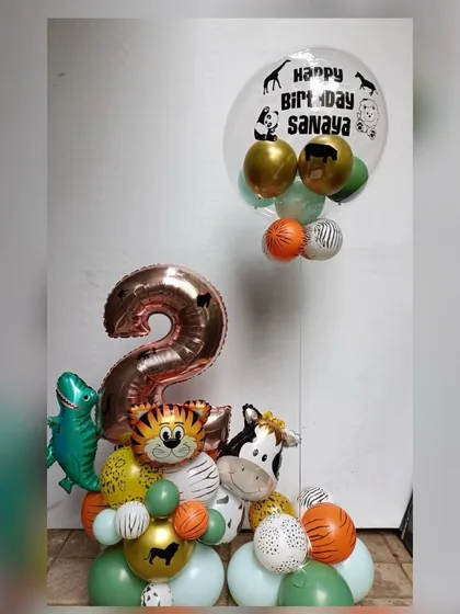 A custom balloon arrangement for a 2nd birthday combining jungle and dinosaur themes. This piece features a rose gold number "2", various animal foils like a tiger and zebra, and a personalized bubble balloon.