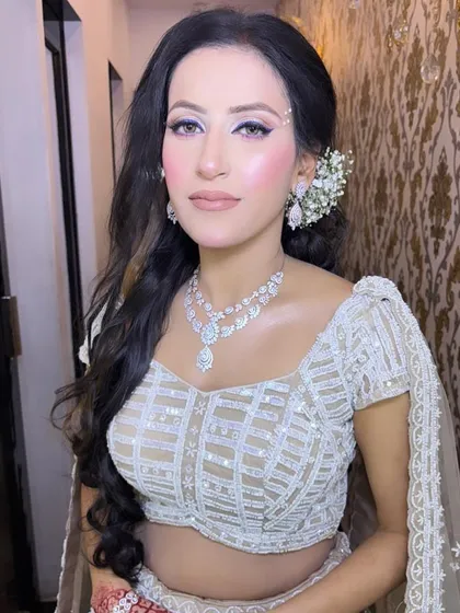 A sophisticated look perfect for a reception or cocktail event. This features a sharp, winged eyeliner and glowing skin, paired with a modern white outfit and diamond jewellery.