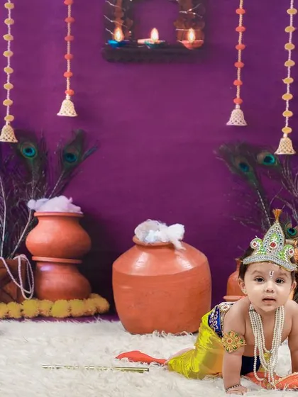 Our Janmashtami mini-session setup, featuring a little Krishna crawling amidst festive decorations like clay pots and peacock feathers.