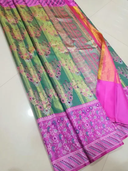 A beautiful silk saree in shades of green and pink with floral woven motifs. The rich colors and soft silk make it a luxurious choice.