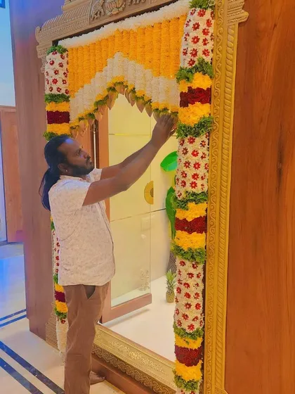 Me giving the final touches to a pooja room door decoration for a housewarming.