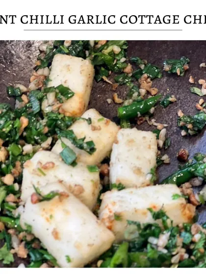 A close-up action shot of the Burnt Chilli Garlic Cottage Cheese being tossed with fresh herbs and chilies. This dish is all about fresh, bold flavors.