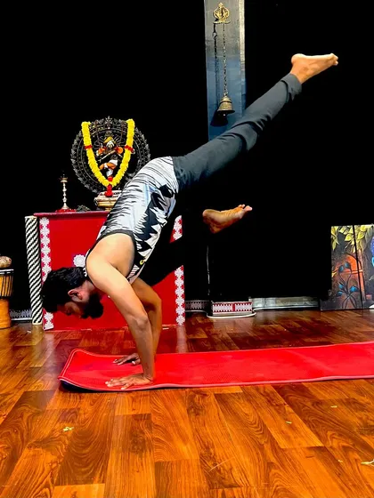 A one-handed handstand variation, a testament to the strength we can build with consistent practice. This pose requires immense focus, balance, and power through the entire body.