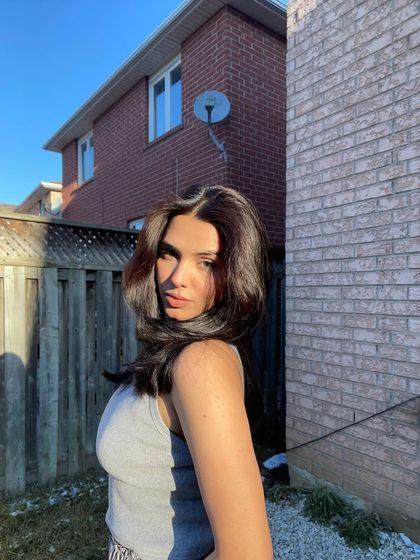 A sunkissed selfie in the backyard during winter, showing the contrast of cold air and warm sun.