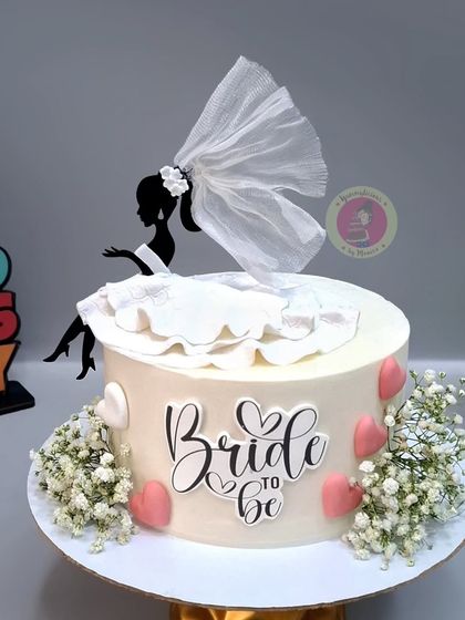 A full view of the elegant "Bride to be" cake with a silhouette topper, perfect for a chic bridal shower.