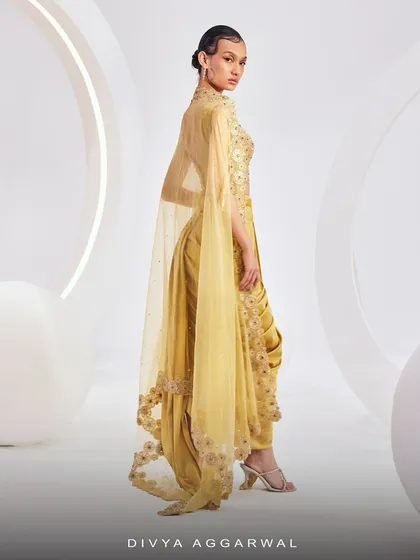 The back view of the LYDIA Cape Set, showcasing the dramatic, floor-length organza cape with 3D floral embroidery.