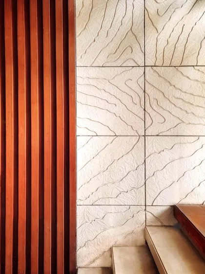 Our philosophy is that art takes nature as its model. This detail shot shows our custom wall art, where we contrasted the linear pattern of Burma Teak wood with an abstract organic design carved into Mint Gwalior stone, inspired by the veins of a leaf.