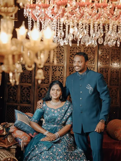 A close-up of the couple in a luxurious, traditionally inspired setting. This portrait highlights their connection and the detailed embroidery of their outfits.