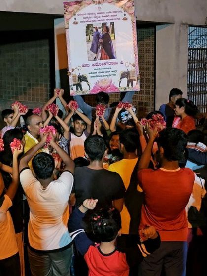 Students holding up flowers and a poster to celebrate an occasion. The sense of community and mutual respect is very strong here.