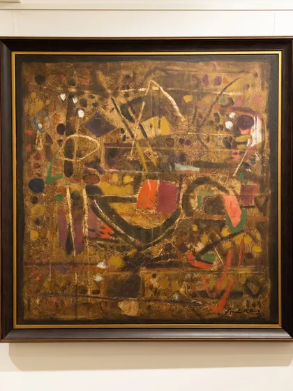 This 1990 abstract by Achutan Kudallur features deep oranges and golds interlocking like a labyrinth, showcasing his ability to create structured chaos and emotional depth.