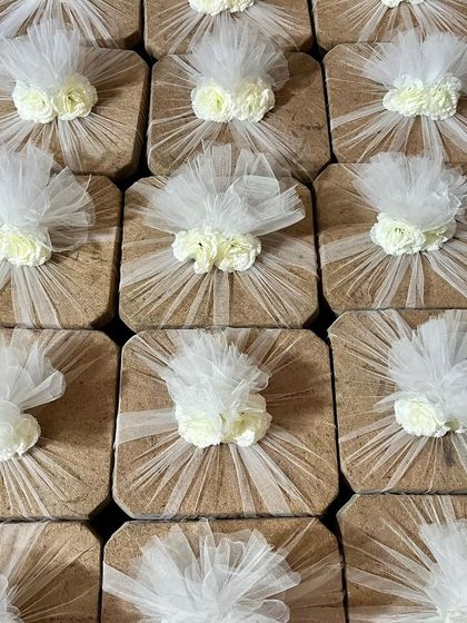 This image shows a large batch of my eco-friendly cork gifts, elegantly wrapped for a corporate event. The natural texture of the cork combined with the delicate white tulle wrapping creates a sophisticated and sustainable gift.
