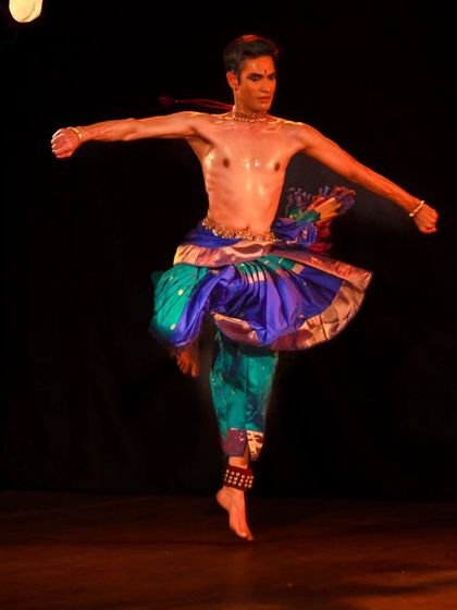 A dynamic spinning jump, capturing the energy and vigor of the 'nritta' or pure dance aspect of a solo performance.