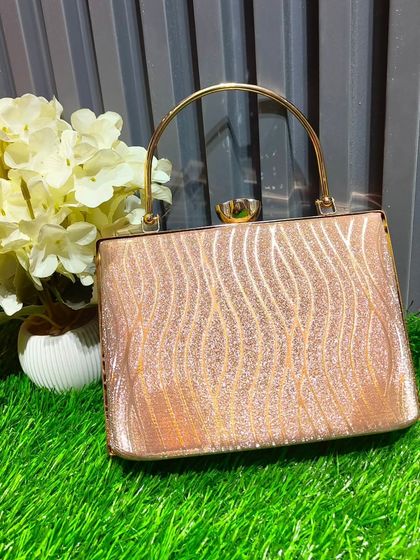 A sparkling rose gold glitter clutch with a delicate wave pattern. This piece is perfect for adding a touch of glamour to your evening wear.