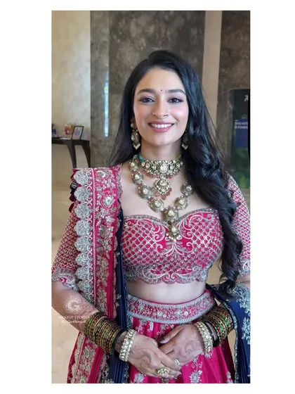 A beautiful smiling shot of Mithila at her reception. The makeup is fresh and youthful, with a pop of color on the eyes that perfectly complements her unique lehenga.