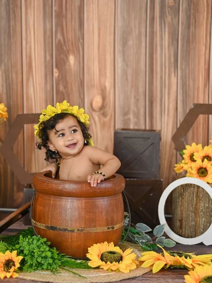A duplicate of image 306, a happy baby in a barrel during a sunflower-themed shoot.