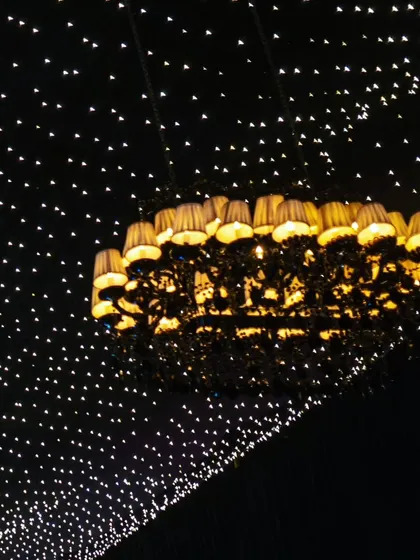 The unique silhouette of the lampshade chandelier against the starry night ceiling.