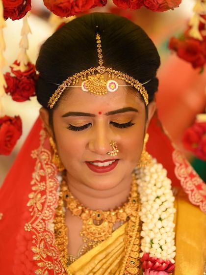 A beautiful close-up of Rashmi under the floral canopy. The makeup is designed to look flawless both up close and from a distance, ensuring she is the center of attention.