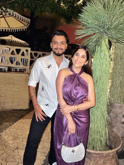 A weekend night out with my husband. I'm wearing a metallic purple dress, and he's in a cool printed shirt. It's all about complementing each other's style.