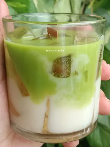 A close-up of the iced matcha latte candle, showing the blend of green and white wax and the realistic wax ice cubes.