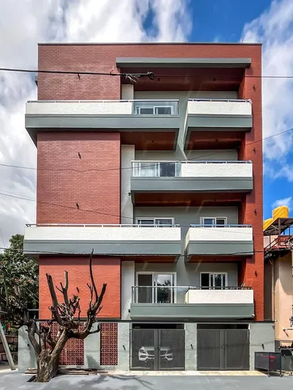 The facade of 'Vihaan,' a multi-dwelling apartment building we designed on a corner site in HSR Layout. We used a dynamic composition of exposed brick, cantilevered balconies, and contrasting textures to create a unique identity for the building.