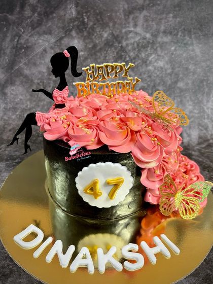 An elegant and glamorous cake for a 47th birthday. The design features a silhouette of a lady whose dress is made of a cascade of pink buttercream rosettes.