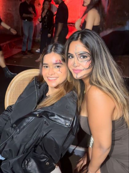 Two friends enjoying the party with their custom Halloween makeup. One features a stitched wound and the other a linear, tribal-inspired face paint design.