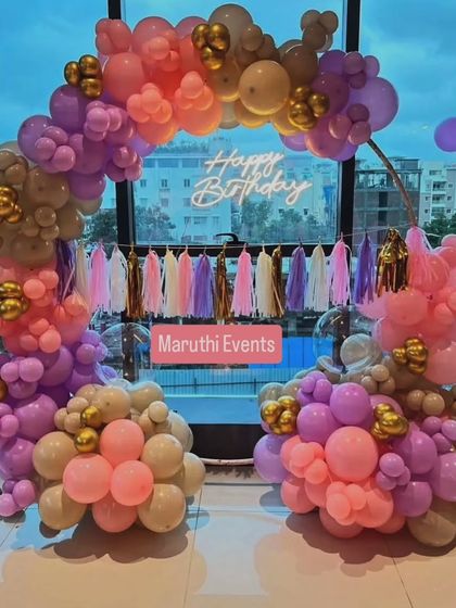 Another view of the stylish retro-colored balloon arch, showing how it looks against a window with a city view.